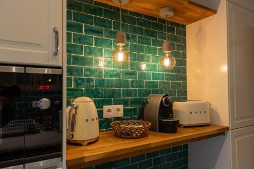 a kitchen with green tile on the wall at Formosa Beach Apartment Vista Mar a 2 Minutos da Praia in Funchal