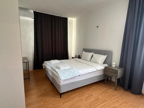 a bedroom with a large bed with blue curtains at Apartman Mandurić in Posušje
