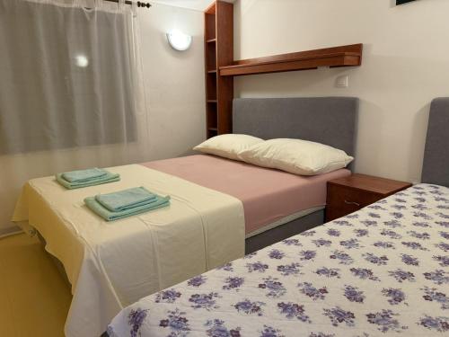two beds in a small room with towels on them at Apartments Edita in Rogoznica