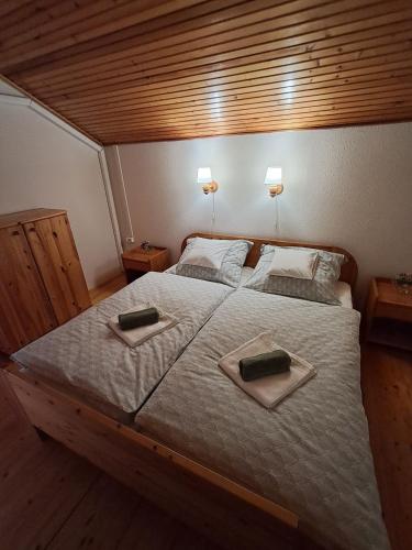 a bedroom with a large bed with two towels on it at Sunshine Vendégház Balatonfenyves in Balatonfenyves