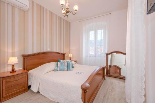 a bedroom with a bed and a dresser and a window at Villa Radovani Jelsa Hvar in Jelsa