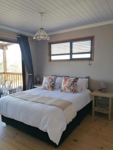 a large bed in a bedroom with a window at The Lekker Plek - Private country cottage in Zuurbraak