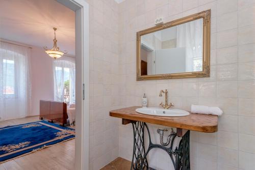 a bathroom with a sink and a mirror at Villa Radovani Jelsa Hvar in Jelsa