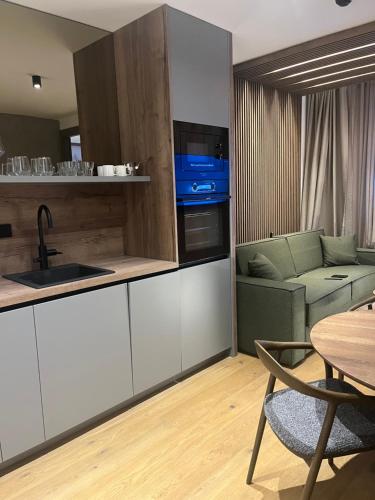 a kitchen and living room with a table and a couch at Apartman hotel 507 in Jahorina