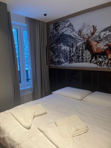 a bedroom with a bed with a picture of a deer on the wall at Apartman hotel 507 in Jahorina