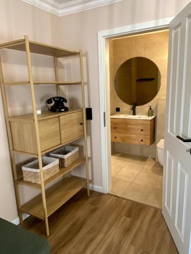 a bathroom with a sink and a shelf with a mirror at Modernes Studio in Irrel in Irrel