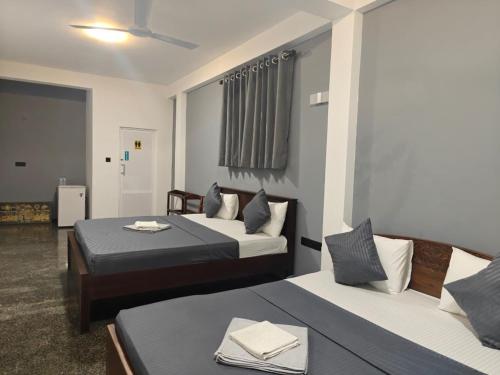 a hotel room with two beds in a room at Nature Lanka Guest House in Negombo