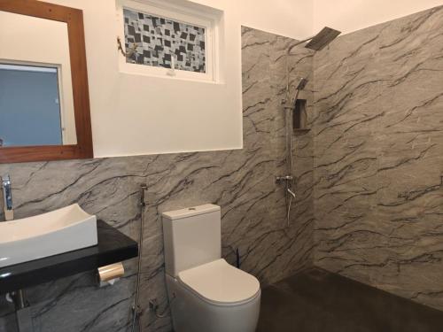 a bathroom with a toilet and a sink at Nature Lanka Guest House in Negombo