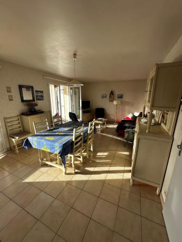 Maison de vacances في Dolus-d'Oléron: غرفة معيشة بها طاولة وكراسي