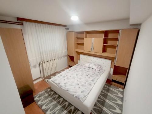 a small bedroom with a white bed in a room at Apartman Alić in Vogošća