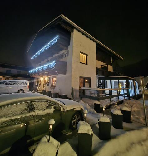 a car parked in the snow in front of a building at Mountain Motel ohne Frühstück in Leutasch