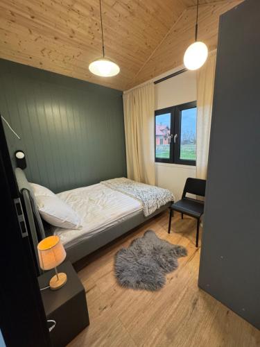 a small bedroom with a bed and a chair at Pniówek Chill in Zamość
