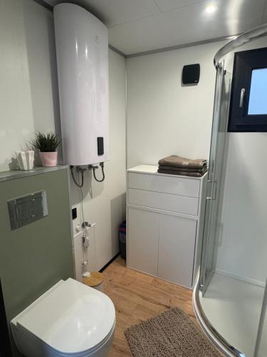 a bathroom with a white toilet and a shower at Pniówek Chill in Zamość
