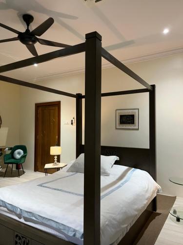 a bedroom with a canopy bed with a ceiling fan at Summerland Seaside Villa in Kampong Telaga Papan