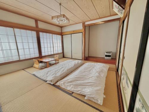 a large bed in a room with windows at 和野 湯沢 in Yuzawa