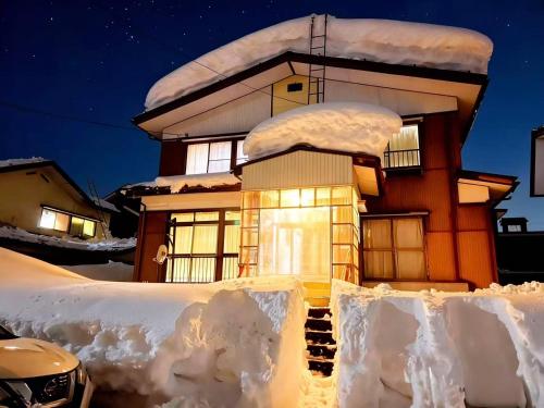 a house covered in snow at night at 和野 湯沢 in Yuzawa