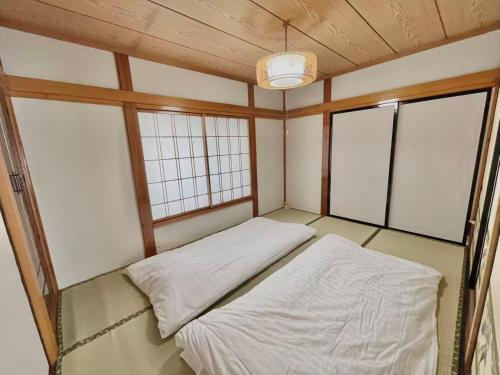 a small room with two beds and two windows at 和野 湯沢 in Yuzawa