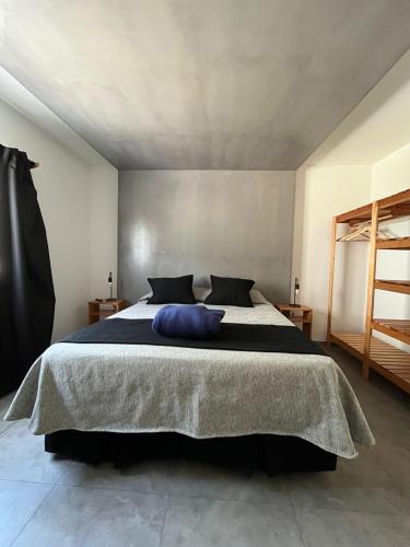 a bedroom with a large bed with a blue pillow on it at Complejo Malama Kai in Mar de Cobo