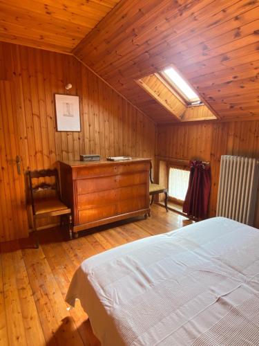a bedroom with a bed and a desk in a room at La Mansarda di Tiziano in Pieve di Cadore