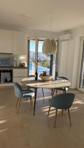 a dining room with a table and chairs and a kitchen at Villa Sun in Naxos Chora