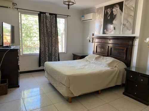 a bedroom with a large bed and two windows at Piso Céntrico Maipú in Maipú