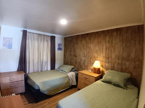 ein Hotelzimmer mit zwei Betten und einem Fenster in der Unterkunft Chalet Valdivia in Valdivia