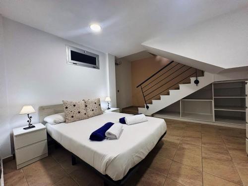a bedroom with a large bed and a staircase at Pablo House Beach in Telde
