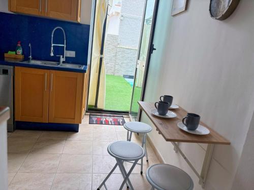 a kitchen with two stools and a table with two cups at Pablo House Beach in Telde