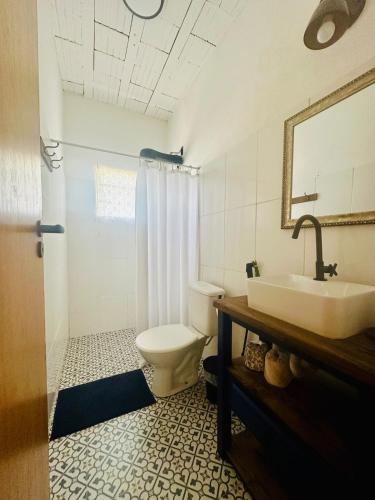 a bathroom with a toilet and a sink at Casinha da Serra in Rio Acima