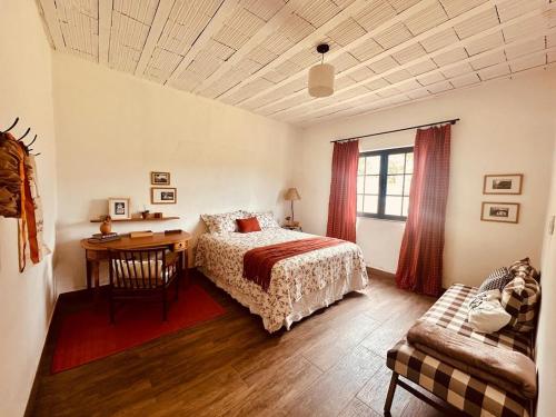 a bedroom with a bed and a desk and a chair at Casinha da Serra in Rio Acima