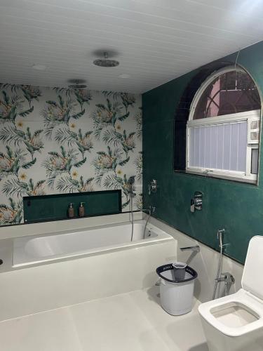 a bathroom with a bath tub and a toilet at Atishay Villa I 4BHK I Pure veg I Pvt Pool & lawn in Lonavala