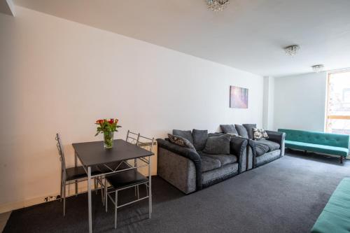 a living room with a couch and a table at Manchester City Square in Manchester