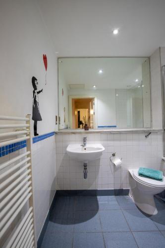 a bathroom with a sink and a toilet and a mirror at Manchester City Square in Manchester