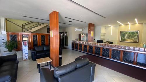 a waiting room with leather chairs and a bar at Tawfiqs Hotel in Barra do Garças