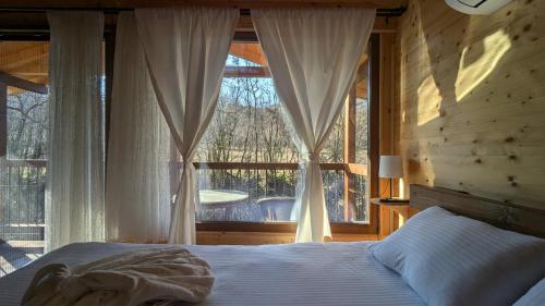 a bedroom with a bed and a large window at Kompleks Etno Luks in Crvulevo