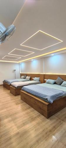 three beds in a room with wooden floors at Flying Fox in Bangalore