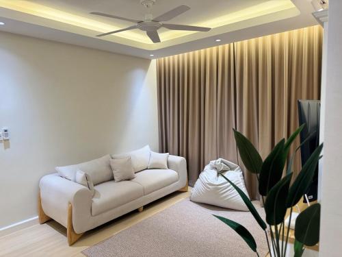 a living room with a white couch and a ceiling fan at InapByDaddy's Near KLIA SIC Sepang 4BR Fully Aircond in Sepang