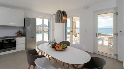 a kitchen and dining room with a white table and chairs at Villa Salt in Naxos Chora