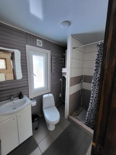 a bathroom with a white toilet and a shower at Під горою 2 in Sheshory