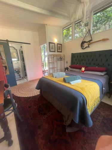 a bedroom with a large bed with a yellow blanket at Waterberry Hideaway in Pringle Bay