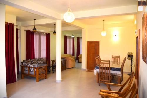 a living room with a couch and a table and chairs at Tea sprig villa in Boralanda
