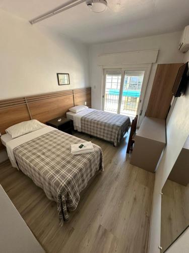 ein Hotelzimmer mit zwei Betten und einem Fenster in der Unterkunft Veneto Hotel in Canguçu