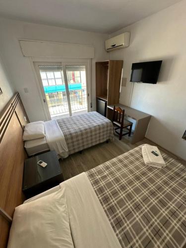 ein Hotelzimmer mit zwei Betten und einem Fenster in der Unterkunft Veneto Hotel in Canguçu
