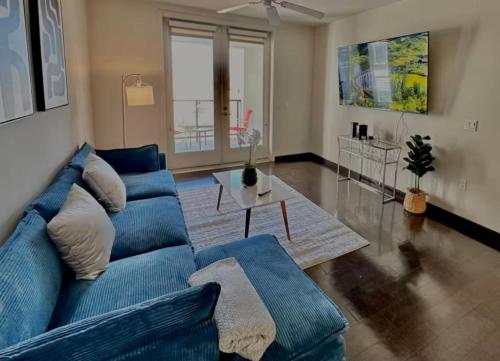 a living room with a blue couch and a table at Hollywood Panoramic Views, Pool, Gym & Free parking! in Los Angeles