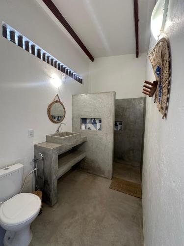 a bathroom with a sink and a toilet in it at BaleiaLofts Kite Village in Itapipoca