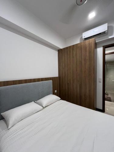 a bedroom with a bed and a tv on a wall at TriZen Luxe Apartments in Colombo