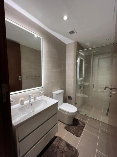 a bathroom with a sink and a toilet and a shower at TriZen Luxe Apartments in Colombo