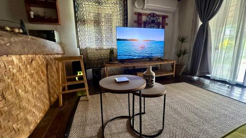 salon z telewizorem i stołem w obiekcie Karoo Lifestyle w mieście Gaborone