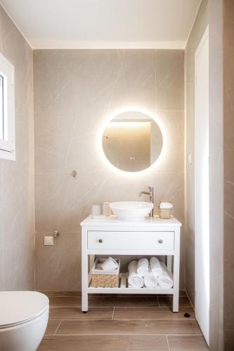 a bathroom with a white sink and a toilet at Tailor Garden House in Tríkala