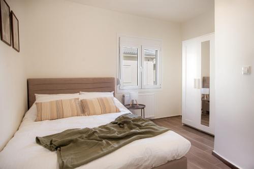 a bedroom with a bed and a window at Tailor Garden House in Tríkala